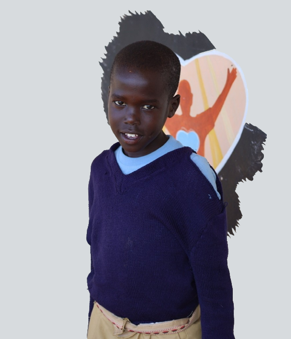 A young boy standing in front of a wall.